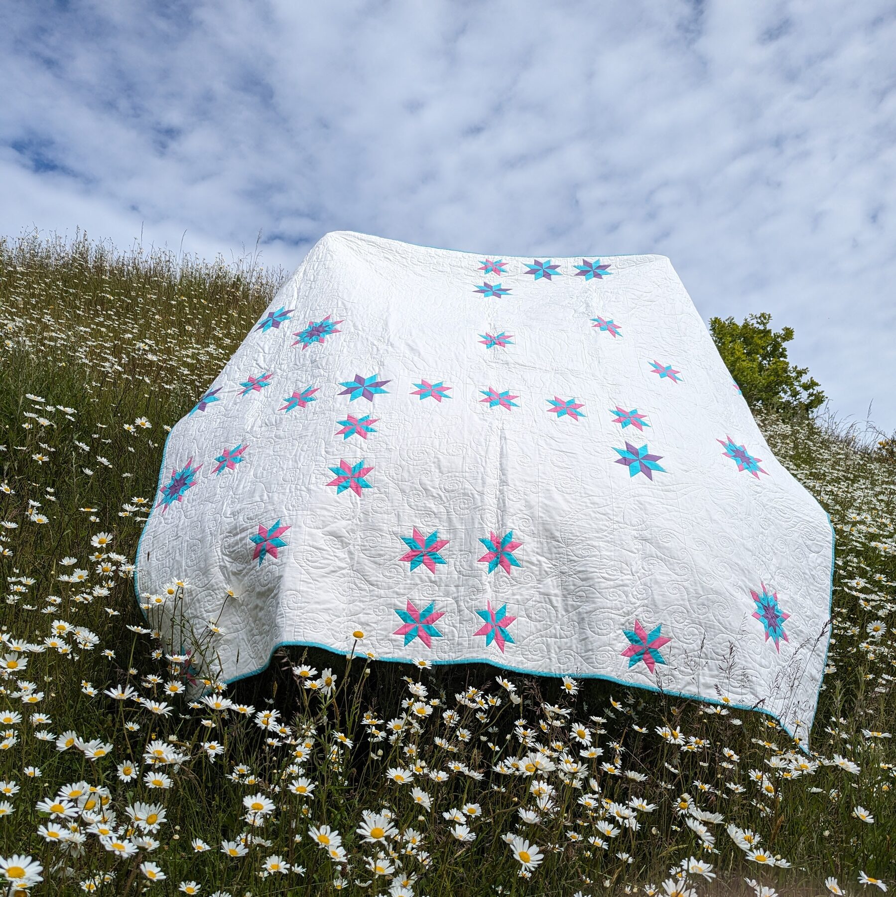 A finished quilt photographed outdoors.